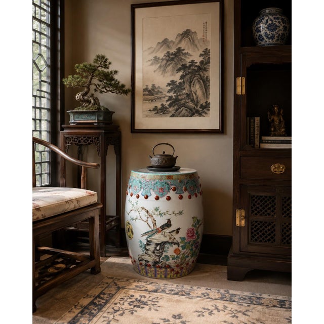 A beautifully decorated vintage Chinese Famille Rose-style porcelain garden stool featuring elegant hand-painted floral...