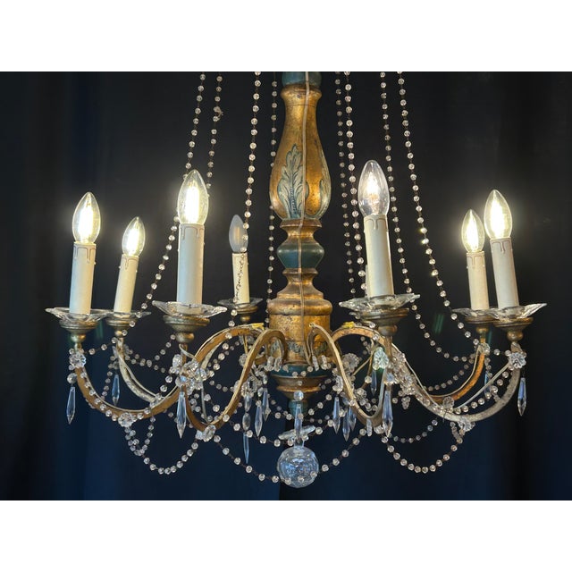 19th-century Italian Genoese chandelier in carved, painted, and gilded wood. Composed of eight light arms. Later...