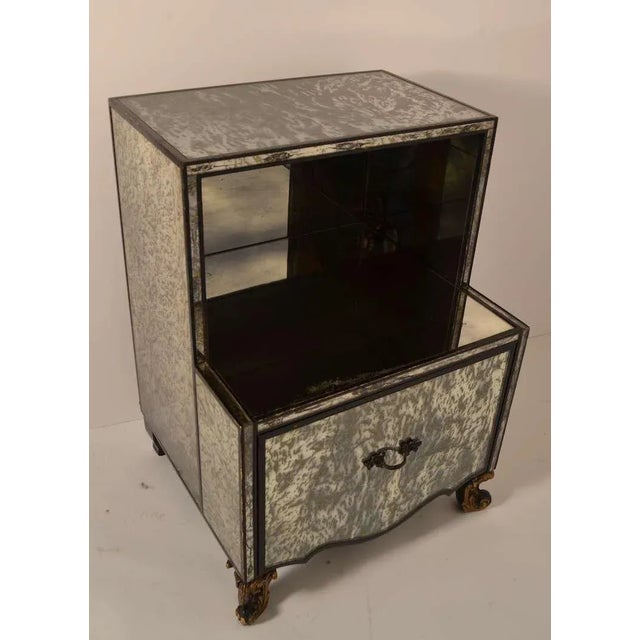 Glamorous marbleized mirrored surfaces with black trim. One ll large drawer and an open cubby space.
