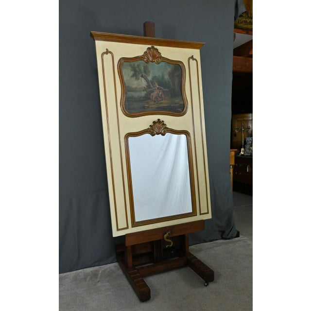 This painted wood trumeau mirror is a beautiful decorative object featuring a romantic scene on wood in the upper part and...