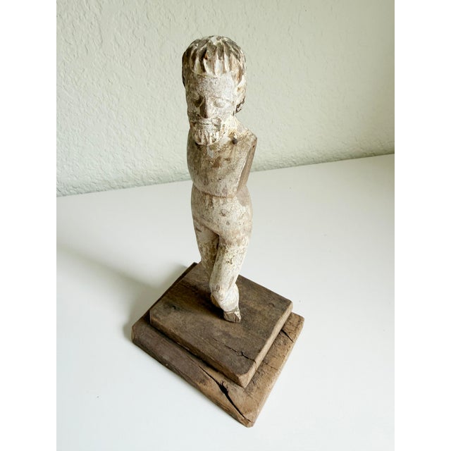 An early religious Santos figure or doll with rustic chipped paint finish attached to a rustic wood base. Likely Spanish...