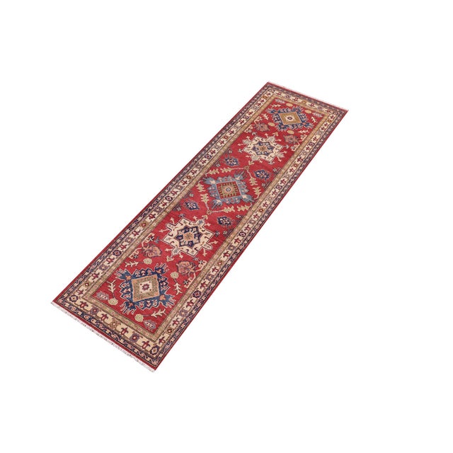 Enhance your home with this exquisite hand-knotted Kazak rug, crafted from fine hand-spun wool and dyed with all-natural...