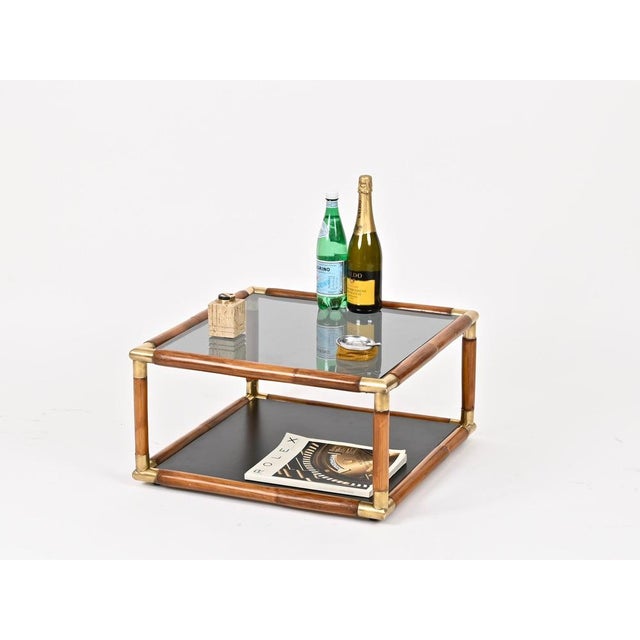 Marvelous and truly unique Mid-Century square coffee table in bamboo and brass, completed by a smoked glass top and a...