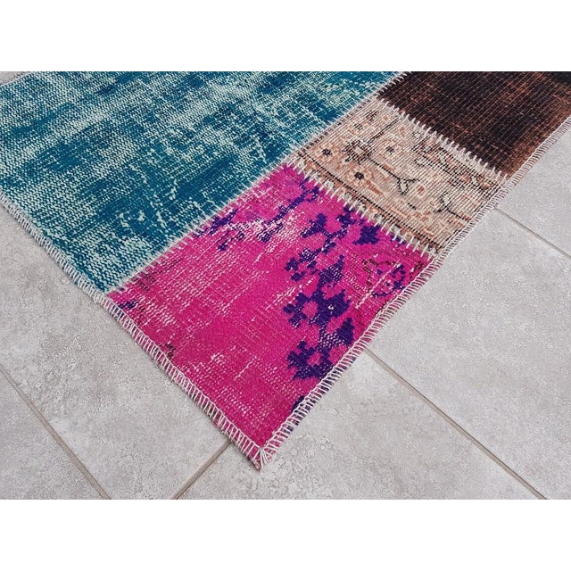 This is a vintage Turkish Oushak rug from the Mid 20th Century. The piece was hand-knotted.