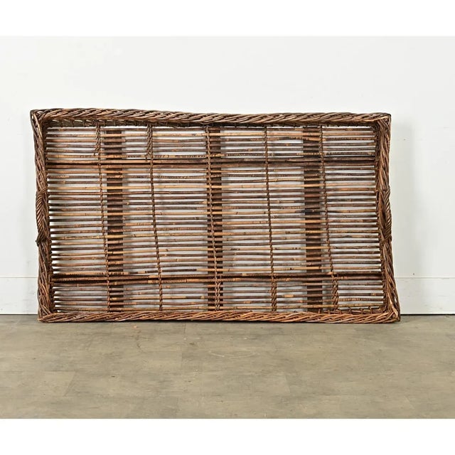 An enormous French basket from the late 19th century, likely used in the vineyards for collecting and harvesting grapes,...