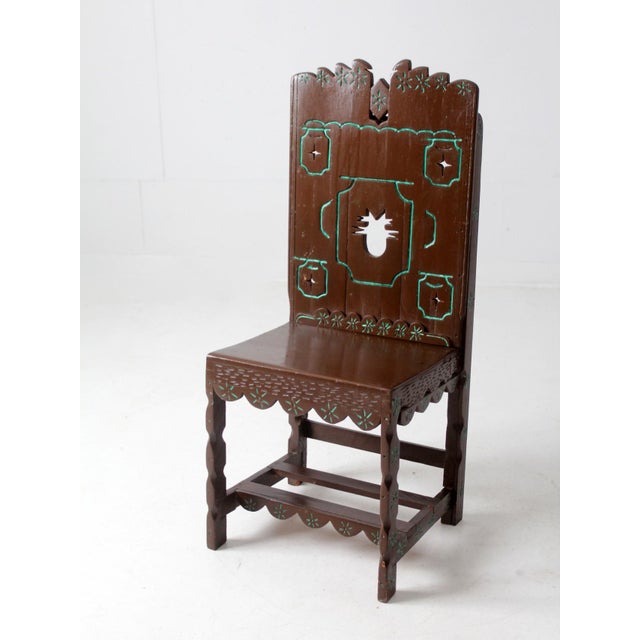This is a vintage American southwest folk art chair circa 1940s. Painted brown with turquoise accents, the large wood...