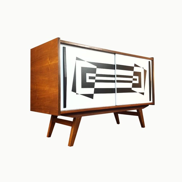 A two-door vintage sideboard manufactured in 1963 at the Słupsk Furniture Factory. The acacia veneer has undergone a...
