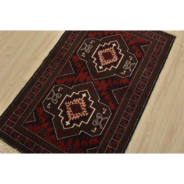 An authentic vintage tribal Baloch rug hand-knotted with fine wool and natural dyes. This nomadic oriental rug features...