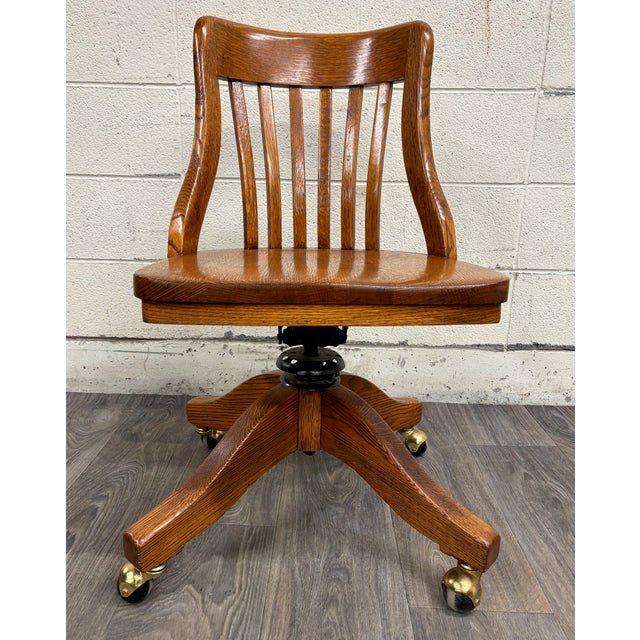 This is an absolutely gorgeous antique oak adjustable swivel desk banker, lawyer, or jury chair or office chair, believed...