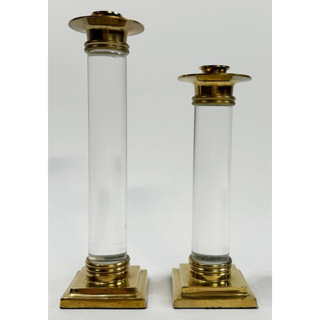 Stately vintage pair of Hollywood Regency style brass and lucite candlestick holders. Taller measures 10.75"H and the...