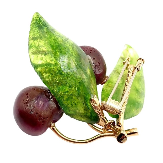 Crafted in 18k yellow gold, this vintage Tiffany & Co. France brooch features rich plique-à-jour green glass leaves and...