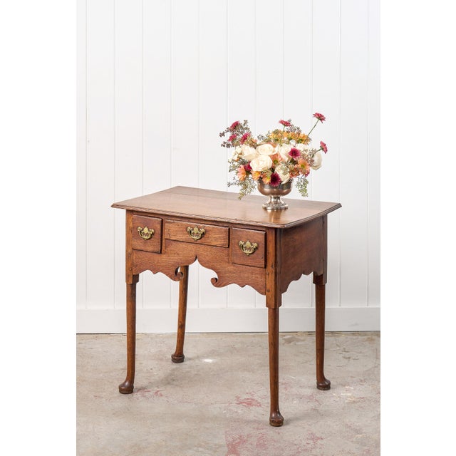 This Georgian-period oak lowboy is a charming side table with a medium oak tone and a soft patina. It features slender...