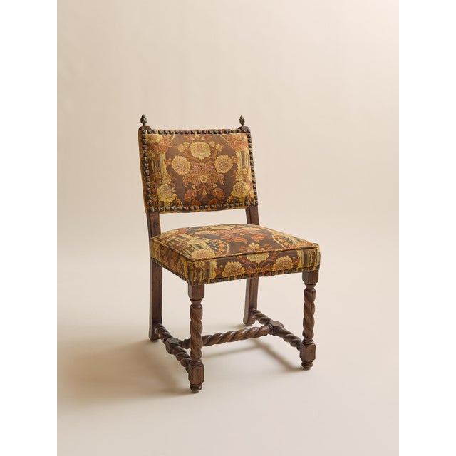 These dining chairs pair richly patterned tapestry upholstery with carved wood frames and turned barley twist stretchers,...