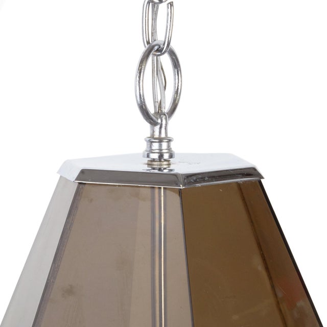 Vintage pendant light from the mid century with 12 dark smoked plexiglass panes which dazzle when lit. Chromed metal...