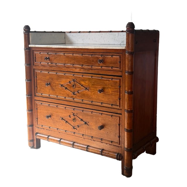 Late 19th-century French faux bamboo chest of drawers featuring a white marble top with raised marble gallery and three...