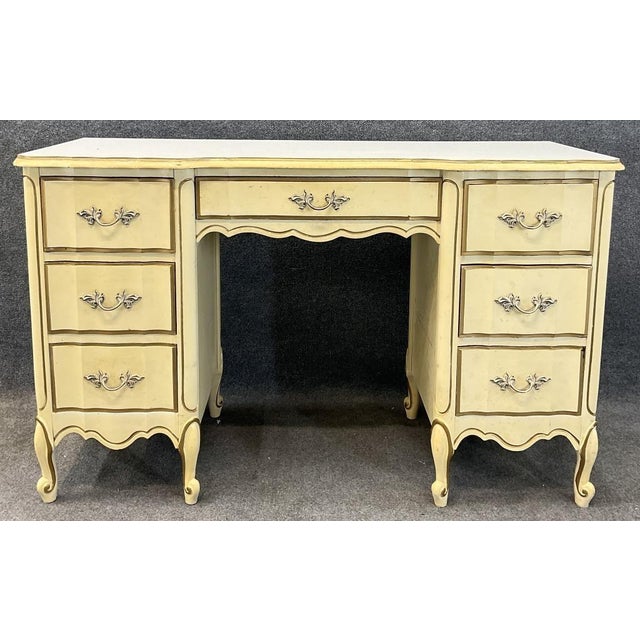 Bring French country charm to your bedroom or workspace with this vintage seven-drawer desk or vanity. Its warm cream...