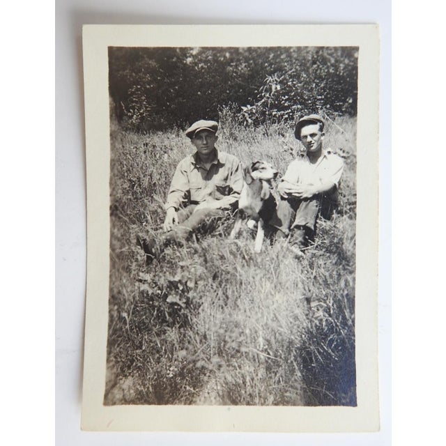 Early 20th century snapshot photograph of two men and their hound dog. Note on back, Paul Daisy and Jim Stege. Unframed.