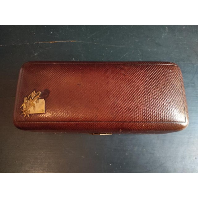 The silver plate appears to be missing a rosebud. The box closes well, but I don't have the key. The leather has some...