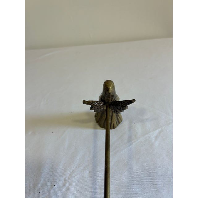 This brass candle snuffer features a whimsical winged angel figure cast at the base, complete with a hooded robe and...