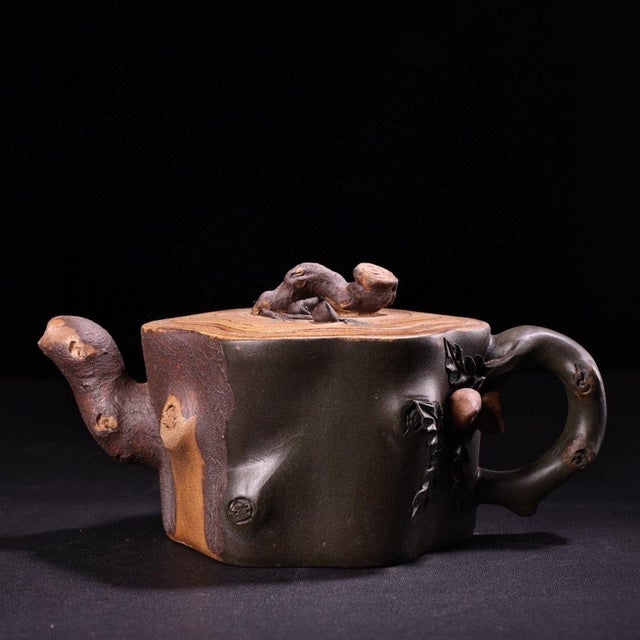 A beautifully executed Yixing zisha teapot in the classic "tree stump" (shuzhuang) tradition, shaped to resemble a cut...