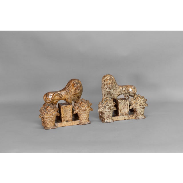 A pair of antique salt-glazed stoneware lion spill holders, applied mouldings from early 19th century window stops....