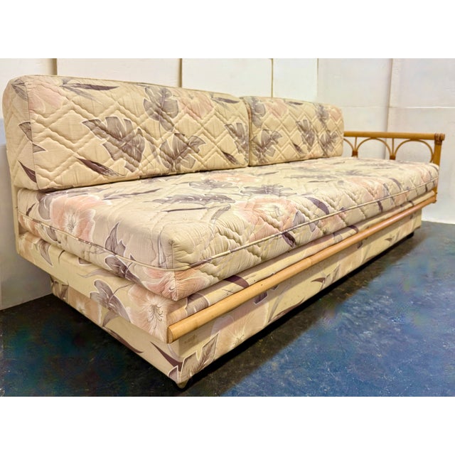 This is a vintage mid-century modern rattan daybed and sleeper sofa, manufactured around the 1970s. It is characterized by...