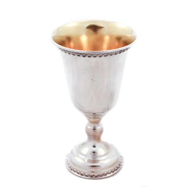 Being offered is a sterling silver goblet. It has a gadroon design around the base and on top along the rim. It has a gold...