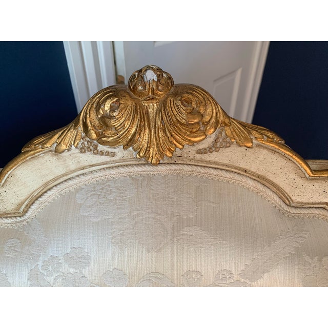 A very comfortable Louis XV Bergère armchair in white damask fabric with gilded details.