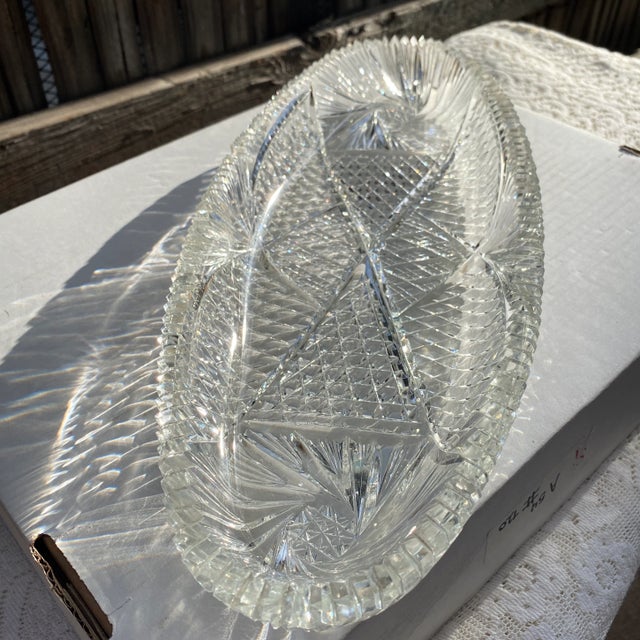 Cut crystal tray features impressive detail. Geometric panels with a daisy button pattern fill most of the tray, accented...