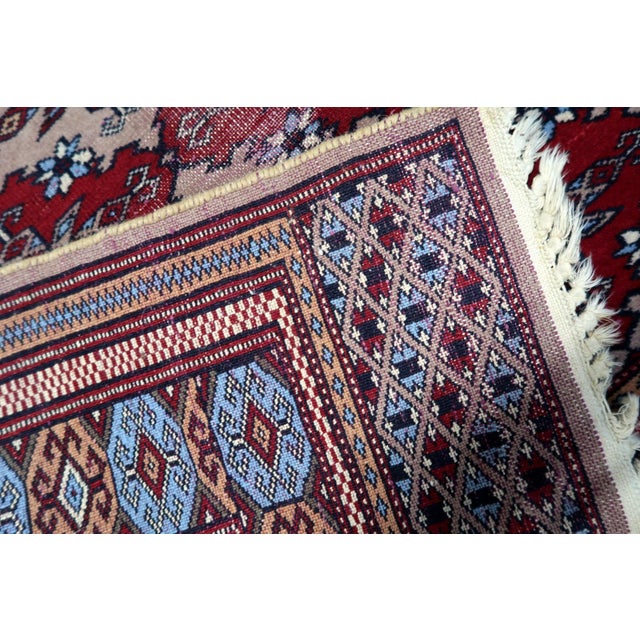 A captivating antique Uzbek Bukhara rug from the 1920s, showcasing the distinctive geometric artistry of Central Asian...
