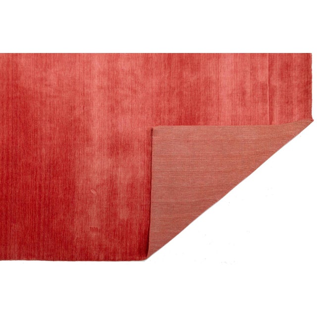 Discover our stunning handcrafted Gabbeh-style wool rug, showcasing a rich crimson red design. Proudly part of our Desert...