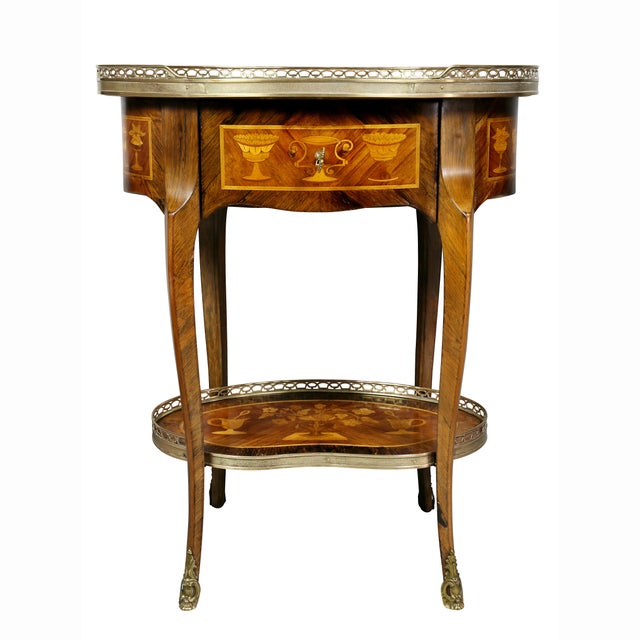 Oval top side table with inlays and brass gallery over a drawer with all around inlays, raised on shaped cabriole legs and...