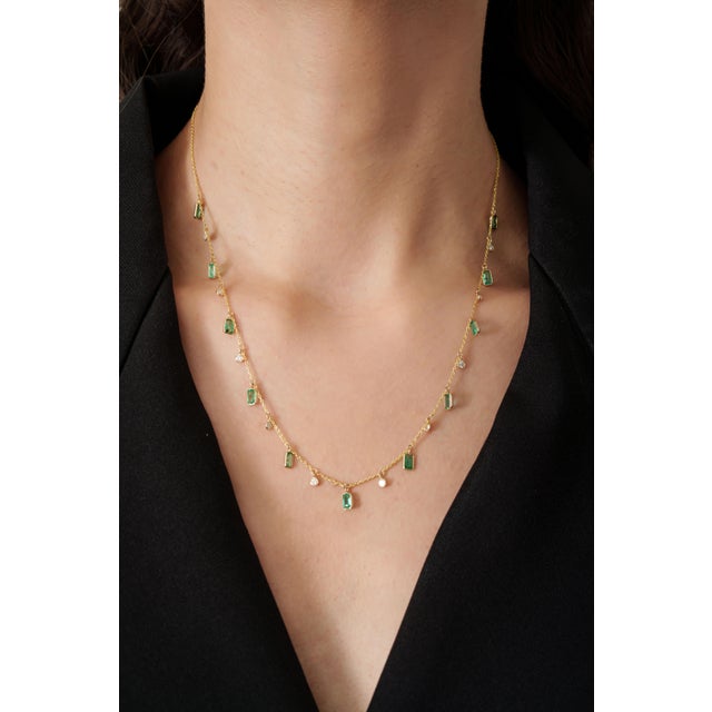 This charm necklace features a 2.4 carat octagon cut emerald set in 14K yellow gold. Each emerald measuring approximately...