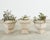 A sculptural set of three Italian molded stone urn planters or jardinieres executed in a warm ivory travertine tone. The...
