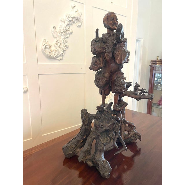 Antique 19th century Chinese root carving of a street vendor holding a shoe raised upon beautifully carved branches. The...