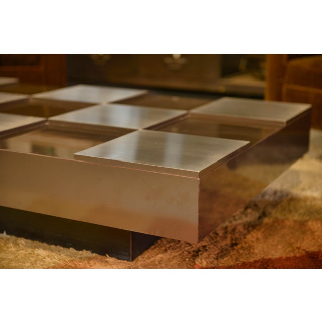 Coffee table with a graphic checkerboard top, alternating metallic squares and lacquered panels. This piece is attributed...