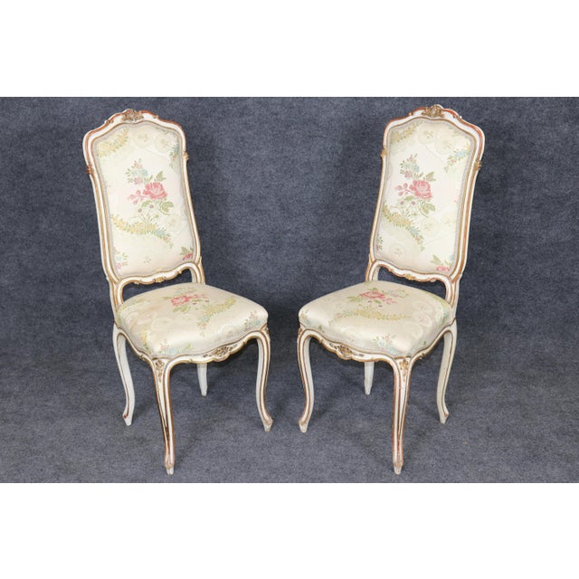 This elegant set of four paint-decorated Louis XV style dining chairs embodies the romance, grace, and refined...