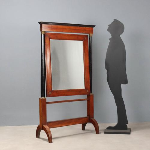 Empire walnut psyche. Column uprights in ebonized wood, embellished with bronze and sheet metal capitals. The tilting...