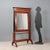 Empire walnut psyche. Column uprights in ebonized wood, embellished with bronze and sheet metal capitals. The tilting...