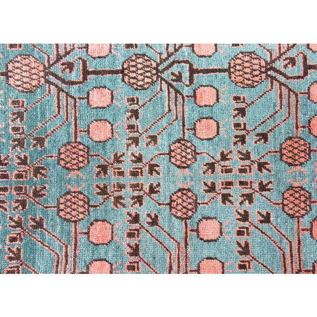 A beautiful early 20th century Central Asian Khotan with an all-over stylized pomegranate motif against a abrash indigo...