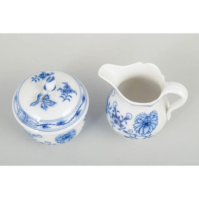 Meissen Blue Onion pattern sugar bowl and cream jug, mid-20th century. A charming set consisting of a classic lidded sugar...