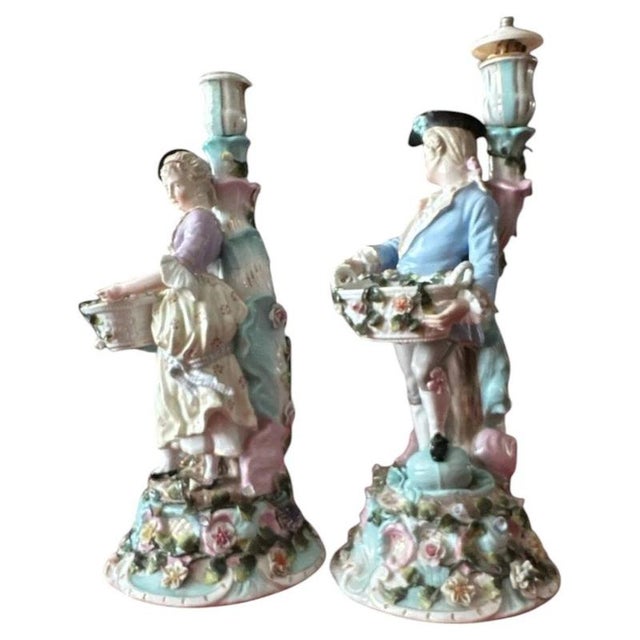 A charming and highly decorative matched pair of antique Sitzendorf porcelain figural candlesticks, dating to the late...