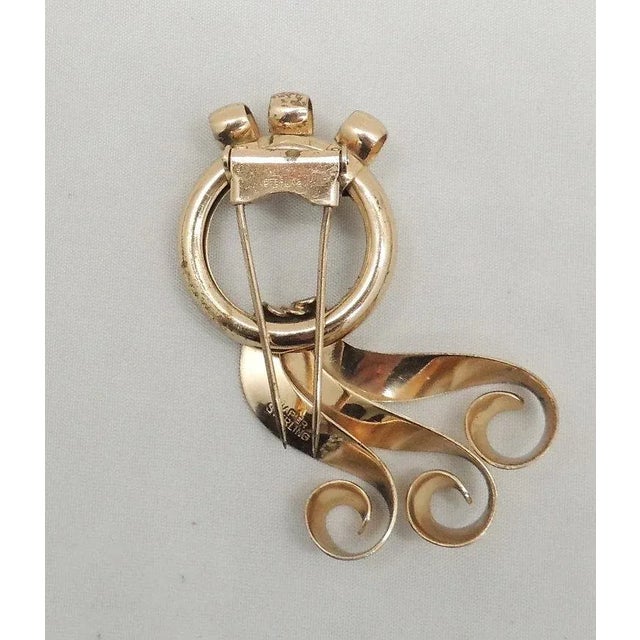 This is part of Chairish’s Costume Jewelry assortment. 1940s Modernist goldtone sterling ribbon fur clip. Marked "Napier...