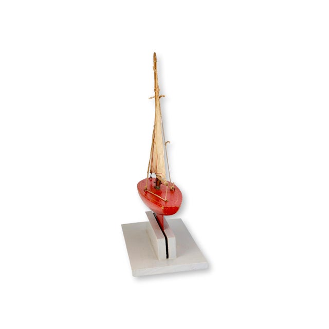 Charming 1950s English pond boat displayed on a later whitewashed stand, featuring a vivid red painted hull with simple...