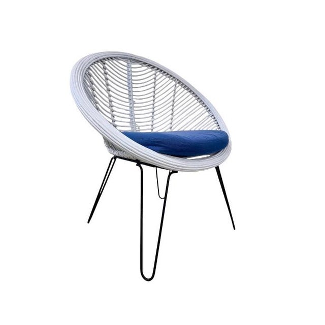 A striking accent chair that blends mid-century modern lines with coastal charm. The sculptural rounded frame is crafted...