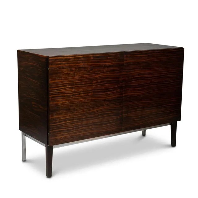 Low rectangular rosewood sideboard, opening with two doors on the front and drawers inside with their chrome handles....