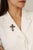 This Victorian style cross brooch pendant is crafted in 925 sterling silver, featuring vibrant round cut emeralds totaling...
