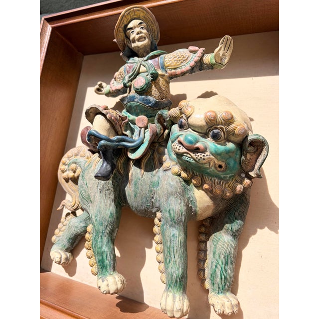 This is a wood framed antique Chinese roof tile featuring a mythical guardian warrior on a foo dog. Handpainted and...