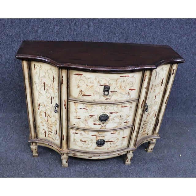 Italian style commode , mahogany top with cream painted base decorated with flowers and other accents, 3 drawer with a...