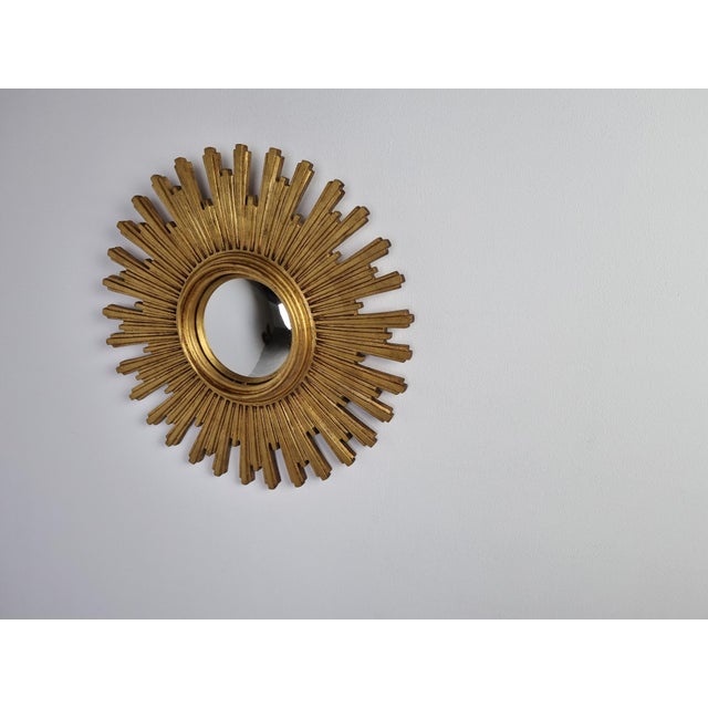 Heavy gilded resin sunburst mirror with convex mirror glass. The golden mirror is in a good condition. 1960s - made in...